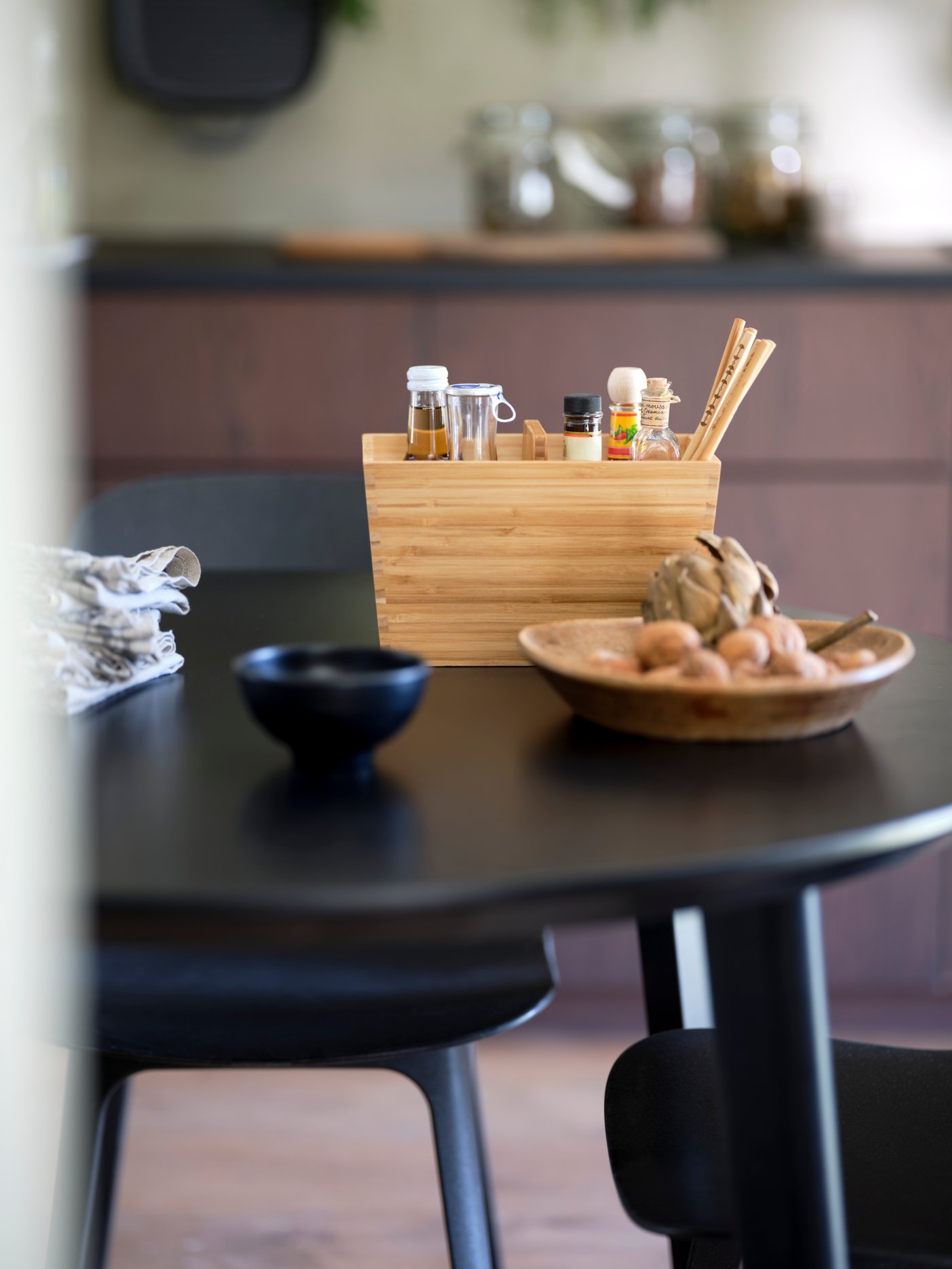 A VARIERA box with spices and bottles on a black kitchen table.