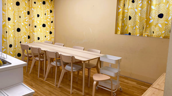 黄色のカラフルなカーテンと、木目が基調なダイニングテーブルが置かれているダイニングルーム。