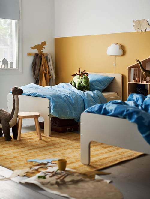 Children's room with extendable bed frame with slatted base, soft toys, quilt cover, pillowcase, rug, lamp, children's stool.