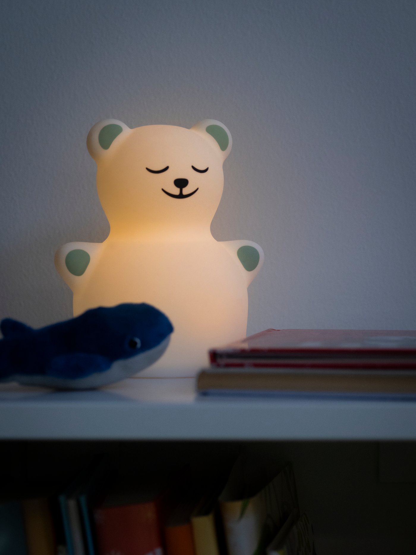 Lähikuva nalle TÖVÄDER LED-yövalaisimesta. Yövalaisimessa palaa valo.