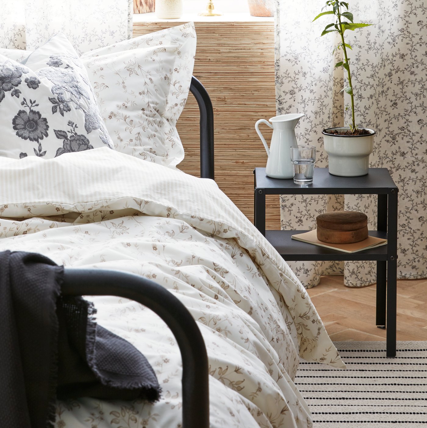 Una cama doble y al costado una mesa de noche KNARREVIK.