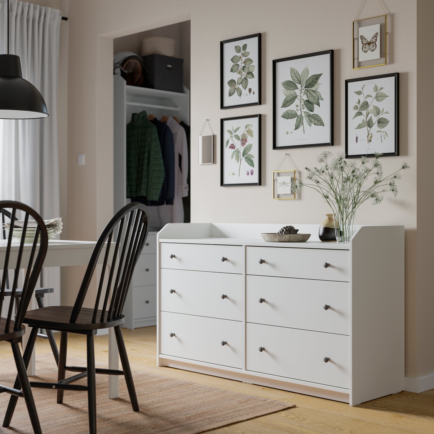 HAUGA chest of 6 drawers in white in a beige dining room. Botanical prints decorate the wall above it.