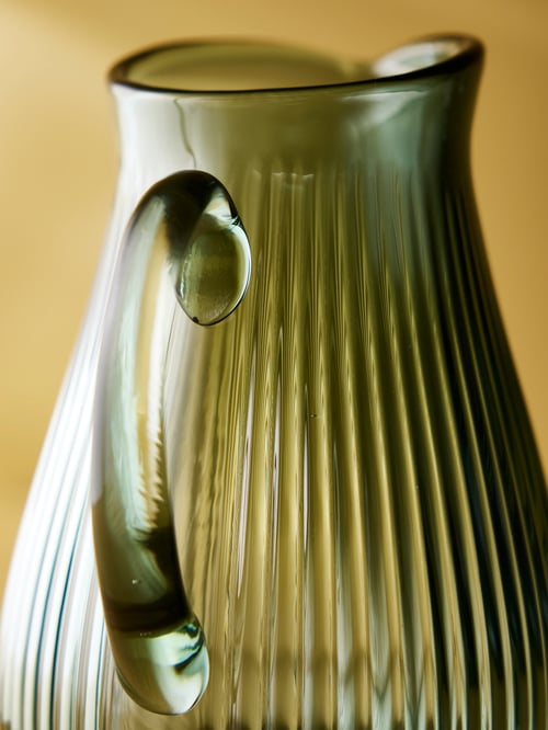 Close-up of the upper portion of a green VARDAGEN jug with a ribbed design. The jug also has a round handle.