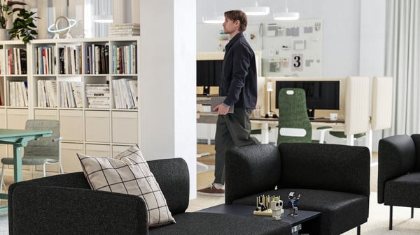 A light, airy office with several black FLINTAN office chairs around a cluster of TROTTEN desks, forming a shared workspace.