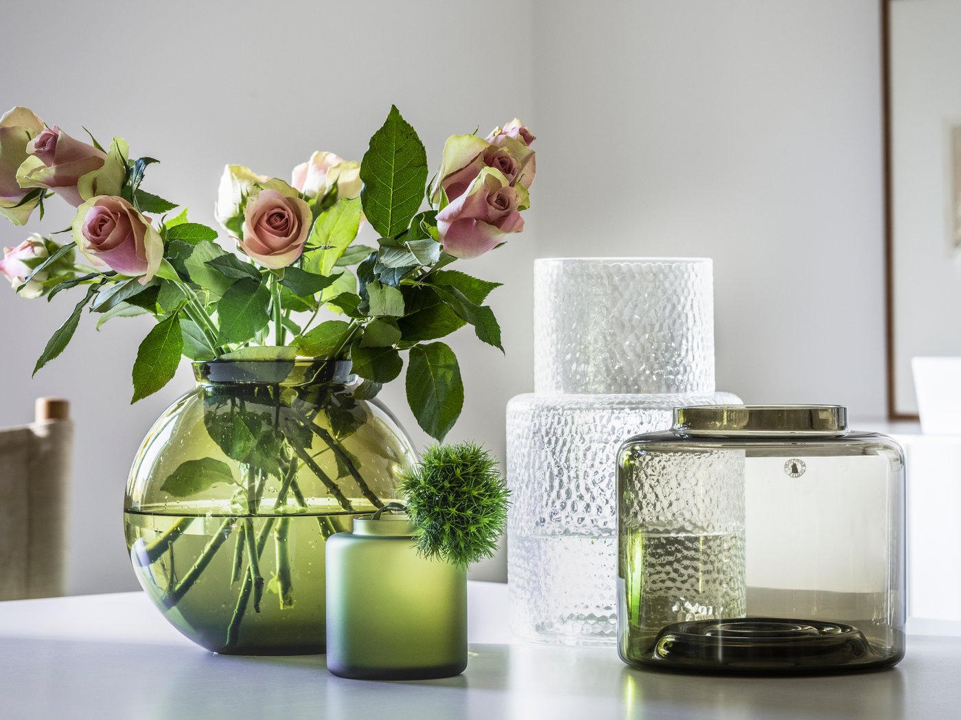 Various KONSTFULL vases. The green vase is filled with dusty pink roses.