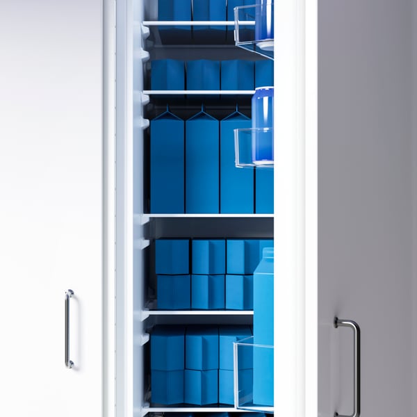 Un frigorífic FORSNÄS integrat darrere de frontals VEDDINGE blancs amb una porta oberta; a dins, s'hi desen envasos de color blau intens.
