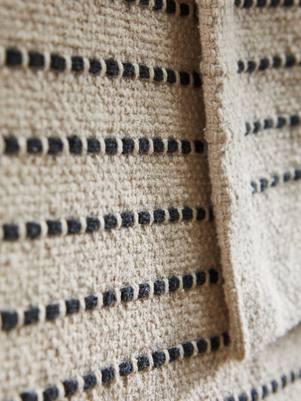 Detailing of the pattern of a natural/black flatwoven STARREKLING rug.