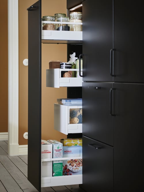 A modern kitchen that features a pull-out drawer with an assembly kit for the pull out function and a jar with a lid. 