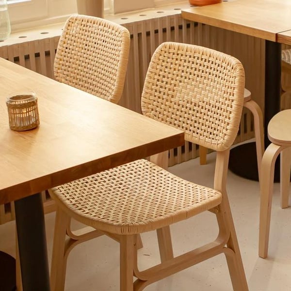Una mesa de comedor de madera con dos sillas tejidas VOXLÖV