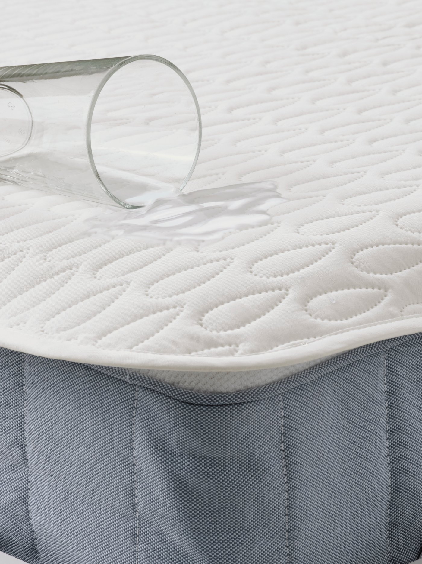 Cubrecolchón impermeable A SOTNÄTFJÄRIL colocado sobre un colchón. 