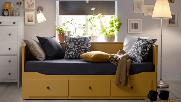 An yellow HEMNES day-bed frame with 3 drawers