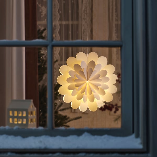 Julbelysning i fönser med en adventsstjärna som ser ut som en blomma. 