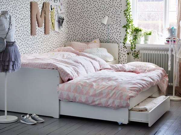 A white FUBBLA LED wall lamp and white SLAKT bed frame in children's room