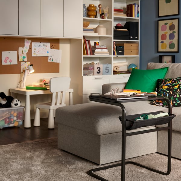 A beige/grey BÅRSLÖV 3-seat sofa-bed with chaise longue in a bright living room, surrounded by a children’s play area.