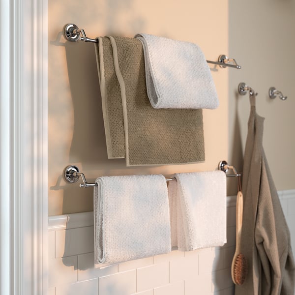 A bathroom featuring a BROFJÄRDEN towel rail with white and beige towels hanging on it.