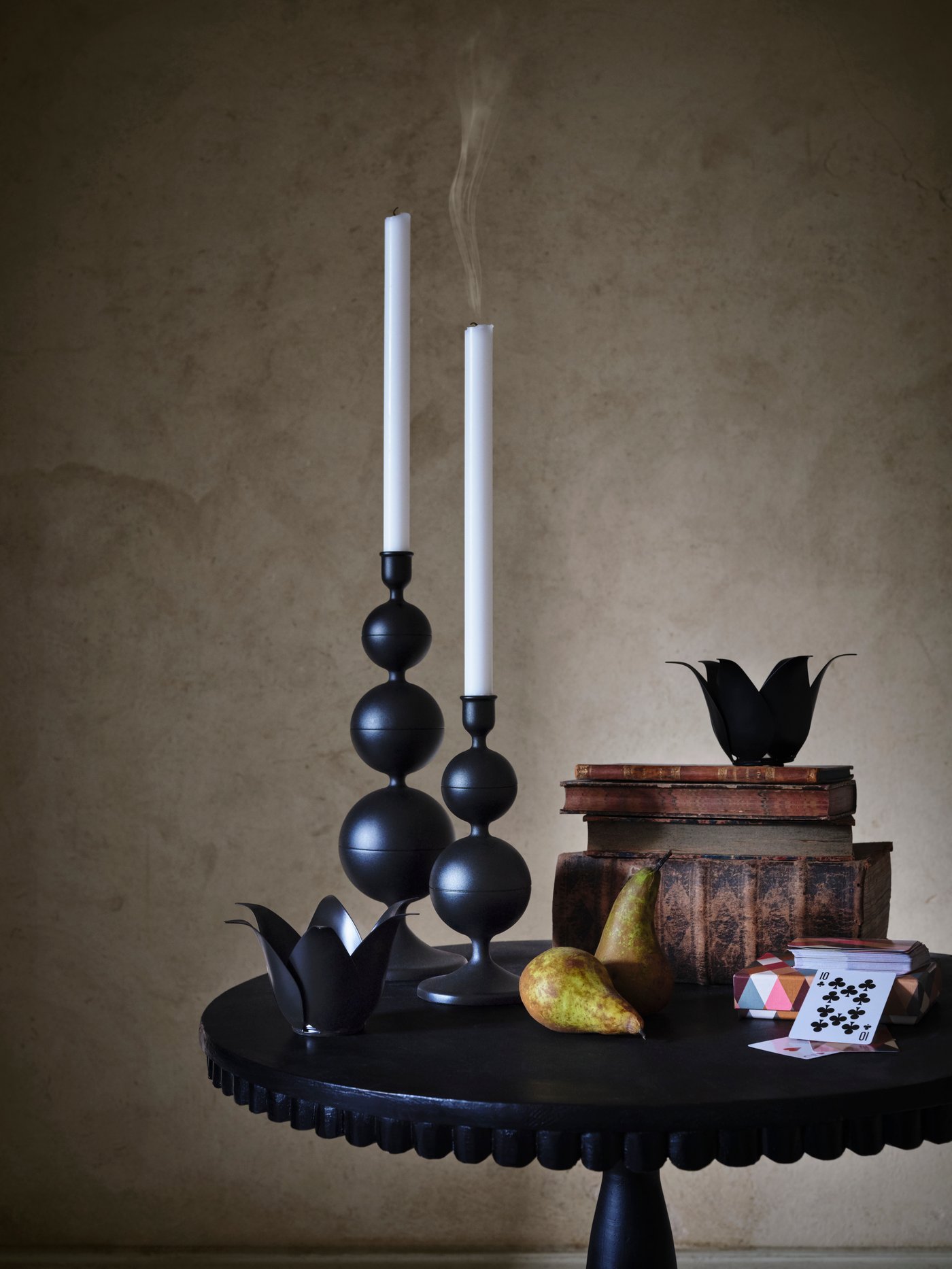 Bi DEKORERA argimutil beltz mahai baten gainean; ondoan, madariak eta liburuak daude pilatuta.