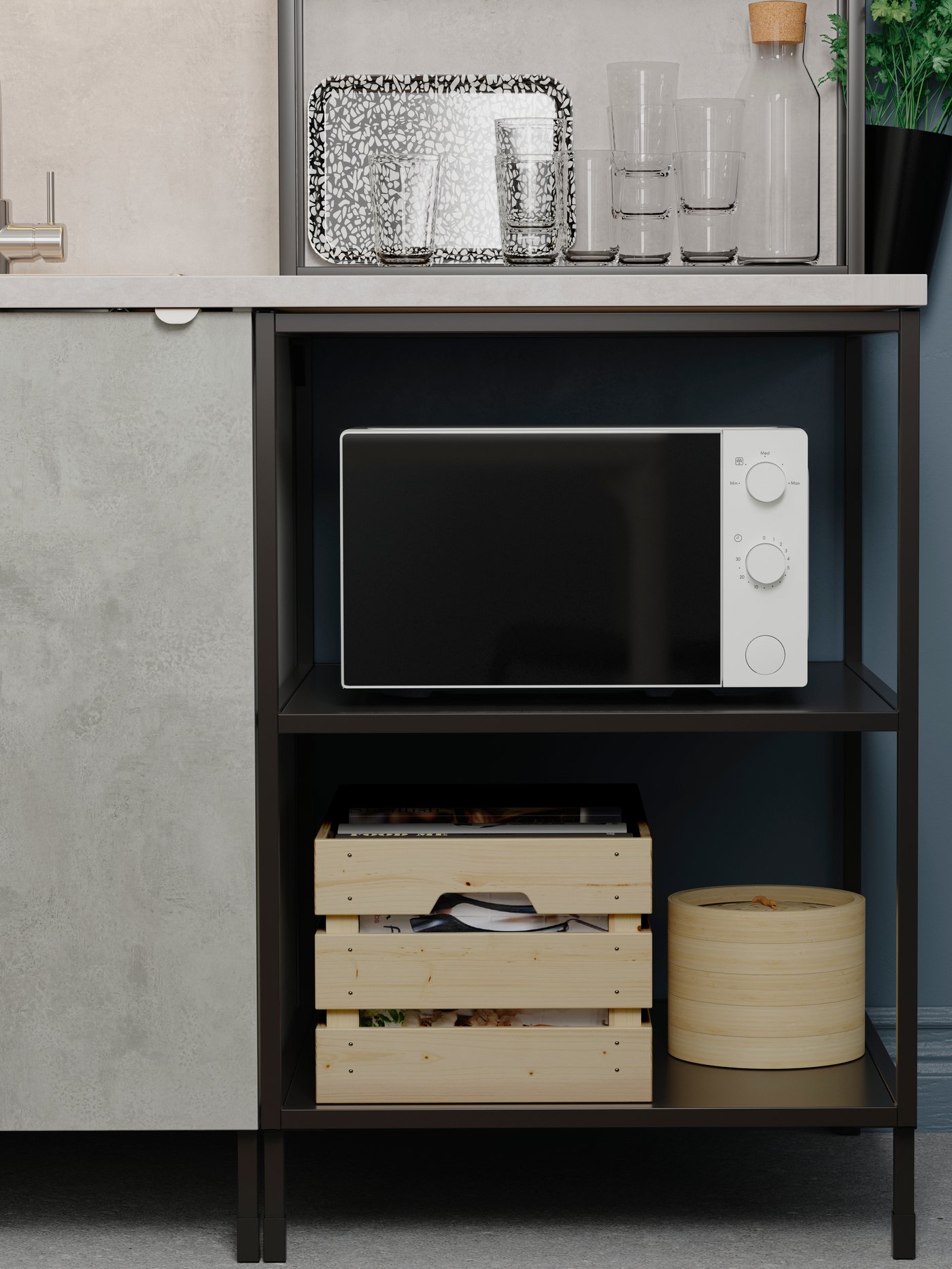 Zona de cocina con una estructura baja con estantes que contiene un horno microondas blanco y una caja rectangular.