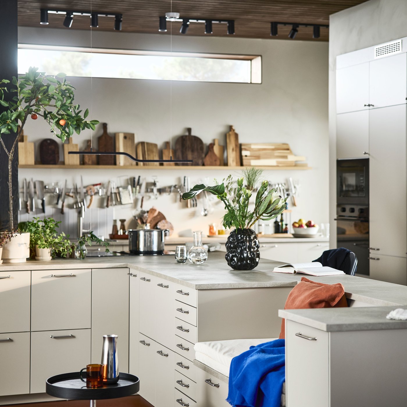A kitchen with white base cabinets features wall storage solutions, including shelves and a KUNGSFORS magnetic rail.
