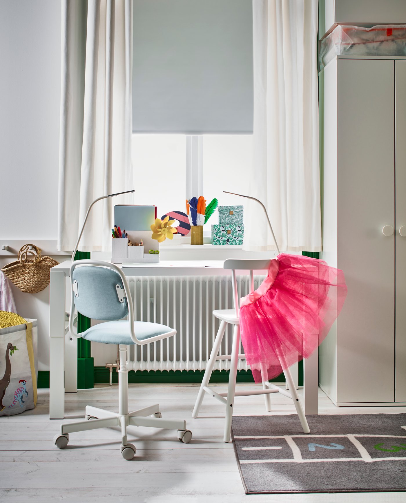 Ein weisser PÅHL Schreibtisch und AGAM Kinderstuhl an einem Fenster im Kinderzimmer.