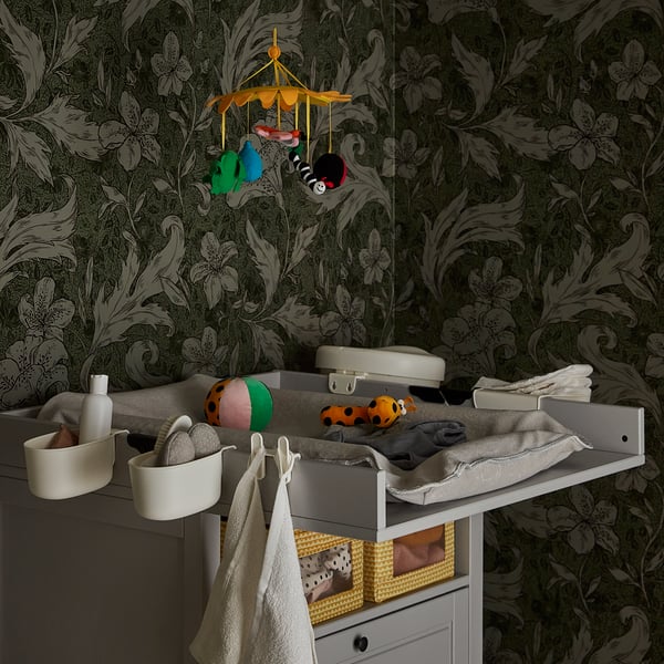 A baby changing table with toys from a KLAPPA mobile.