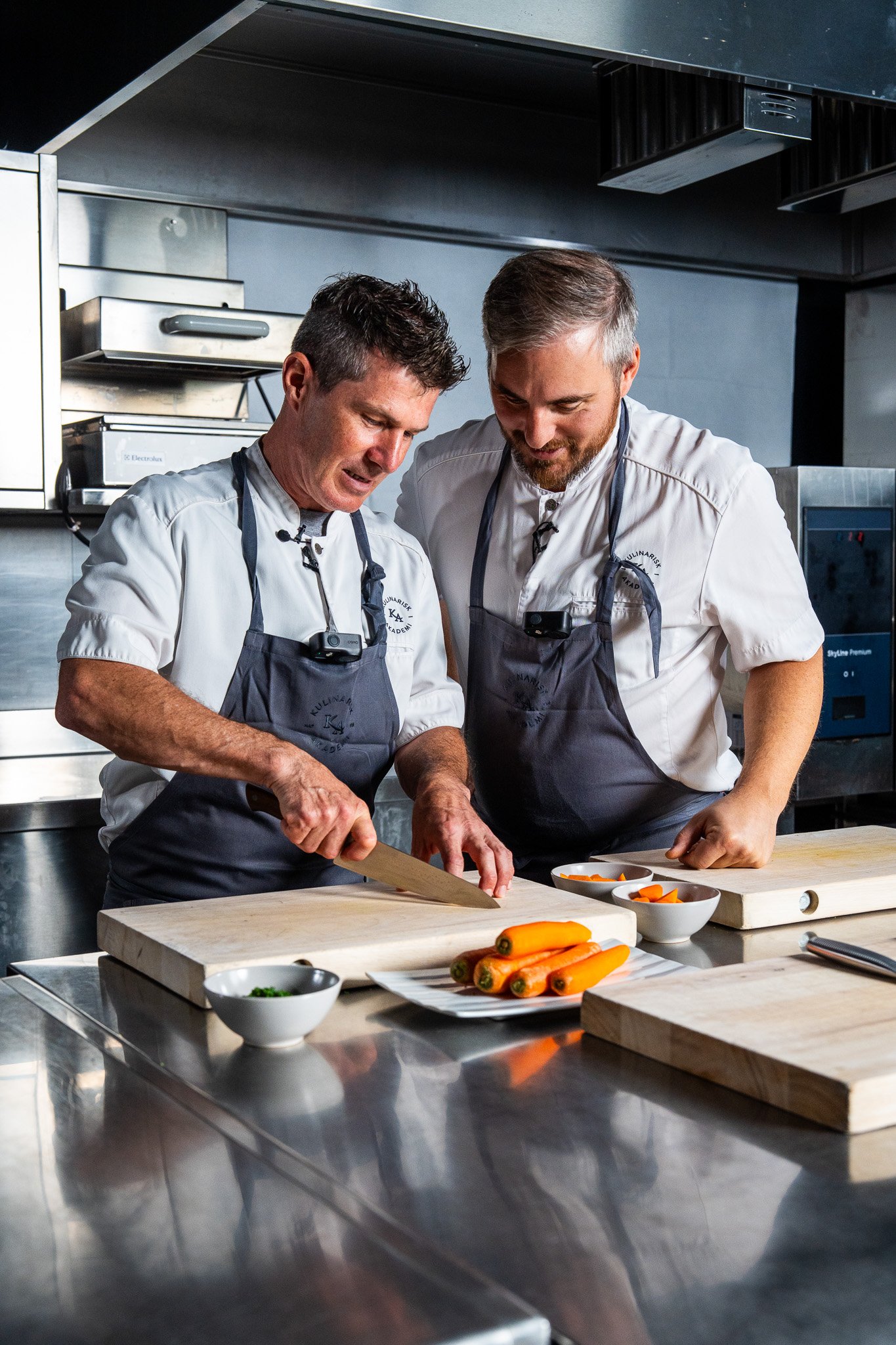 To mesterkokker i kulinarisk akademi tester IKEAs kokkekniver på storkjøkkenet.