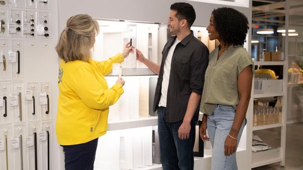 Ikea coworker showing two customers cabinet door options