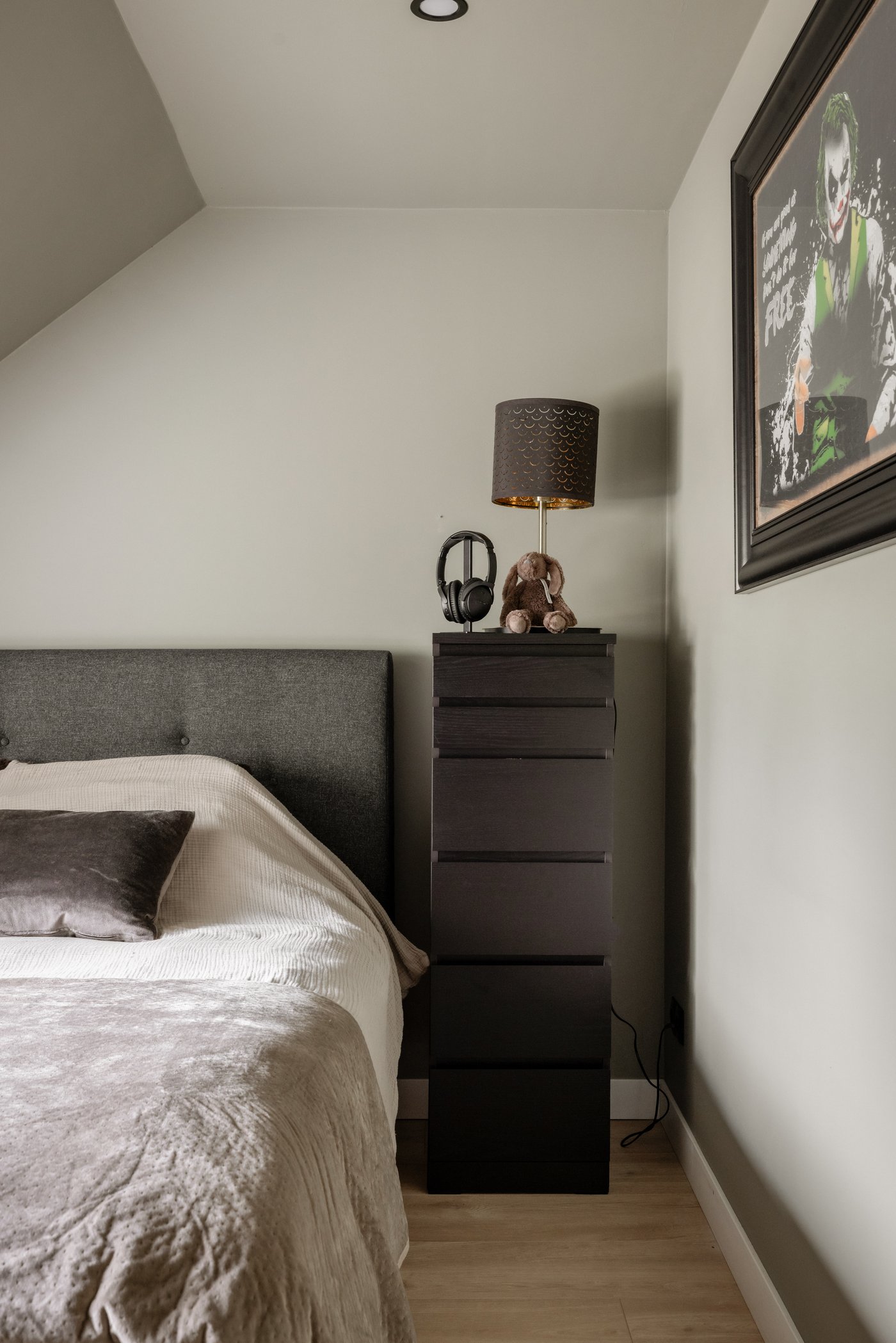 Hoek in de slaapkamer waarin een zwarte MALM ladekast met 6 lades staat. Op de kast staat een NYMÖ / SKAFTET lamp.