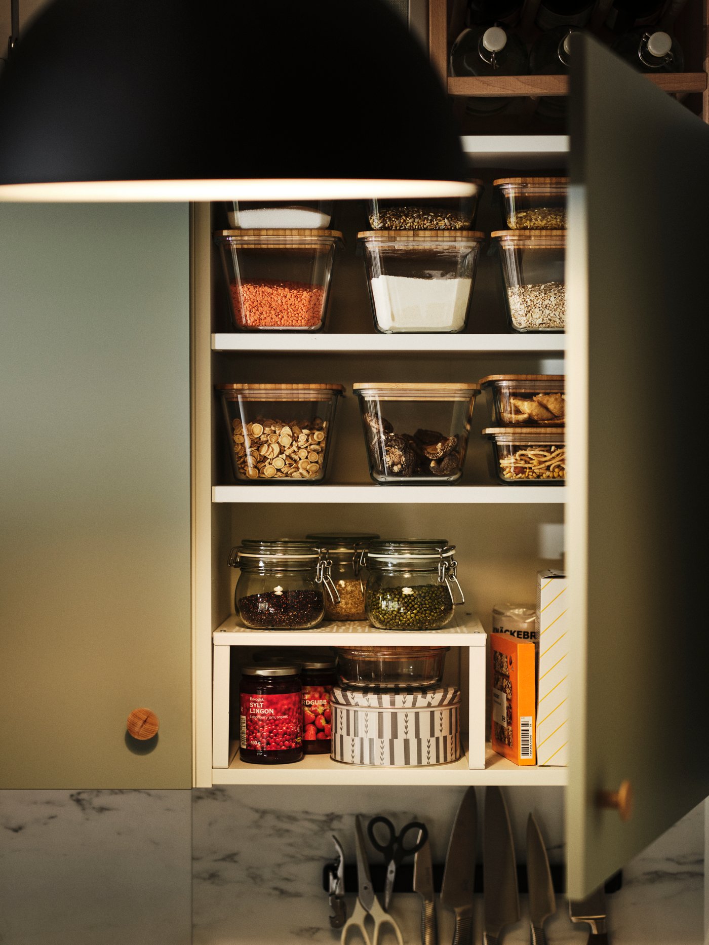 Estante adicional VARIERA en un armario de pared ENHET con varios recipientes para alimentos IKEA 365+ y tarros con especias.