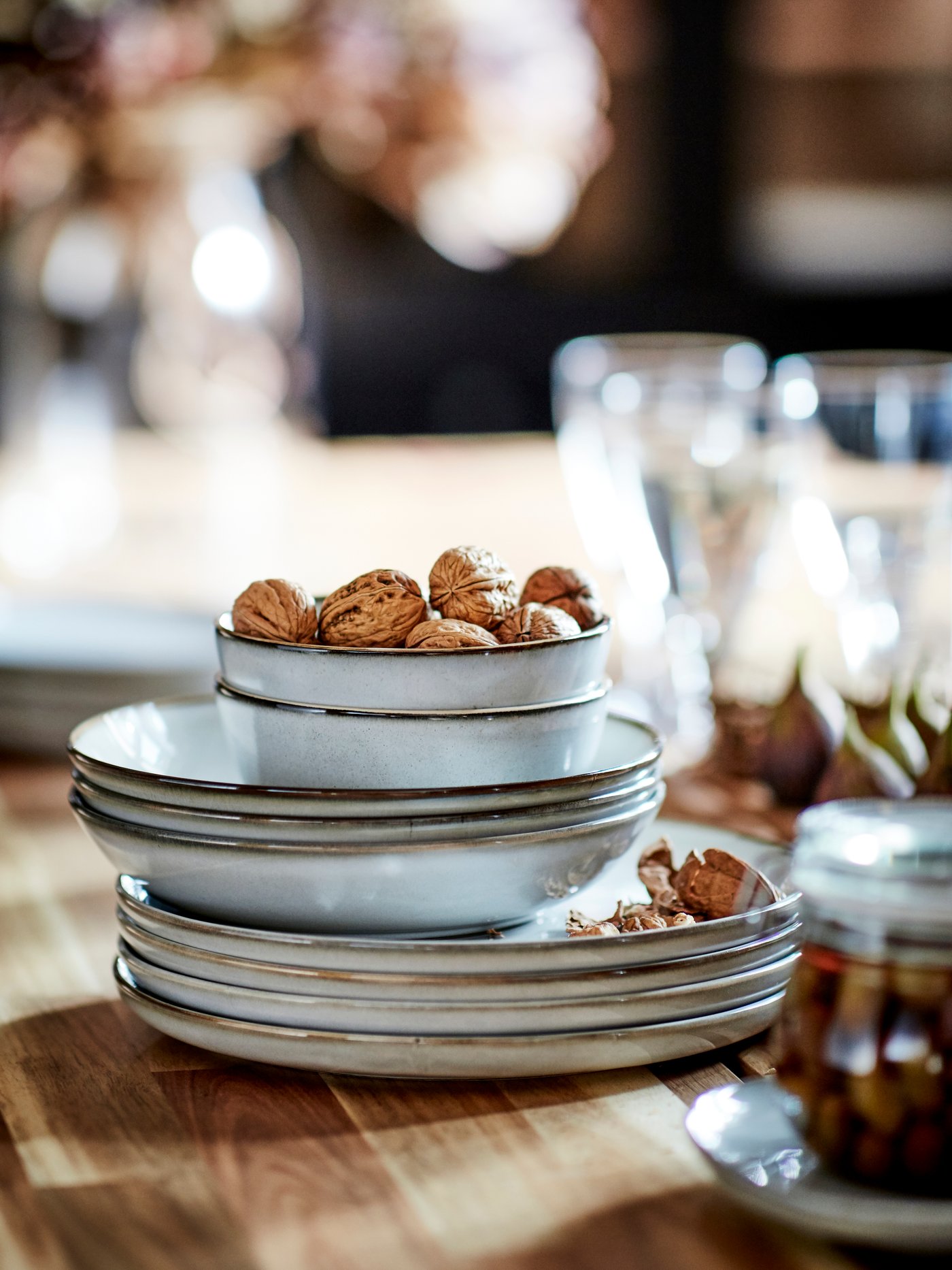 Table setting with a white patterned FRIKOSTIG bowl; the table is set with candles, glassware and silver.