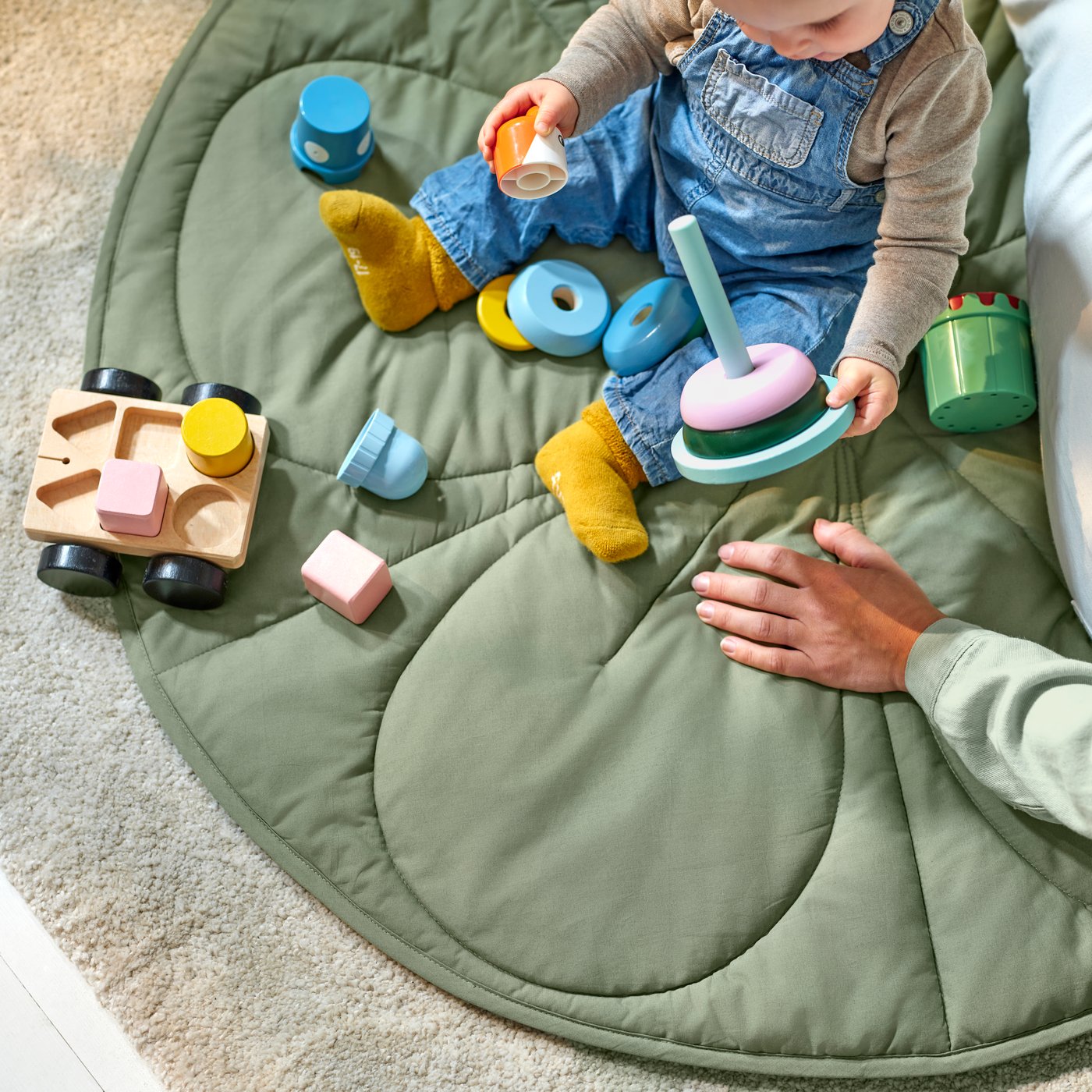 A green/beige striped GULDVÄVARE quilted blanket