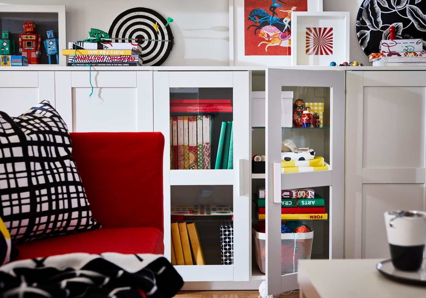 Otwarta szuflada szafki pod telewizor BRIMENES w kolorze czarnym. W oddali widoczne regału serii BRIMNES.