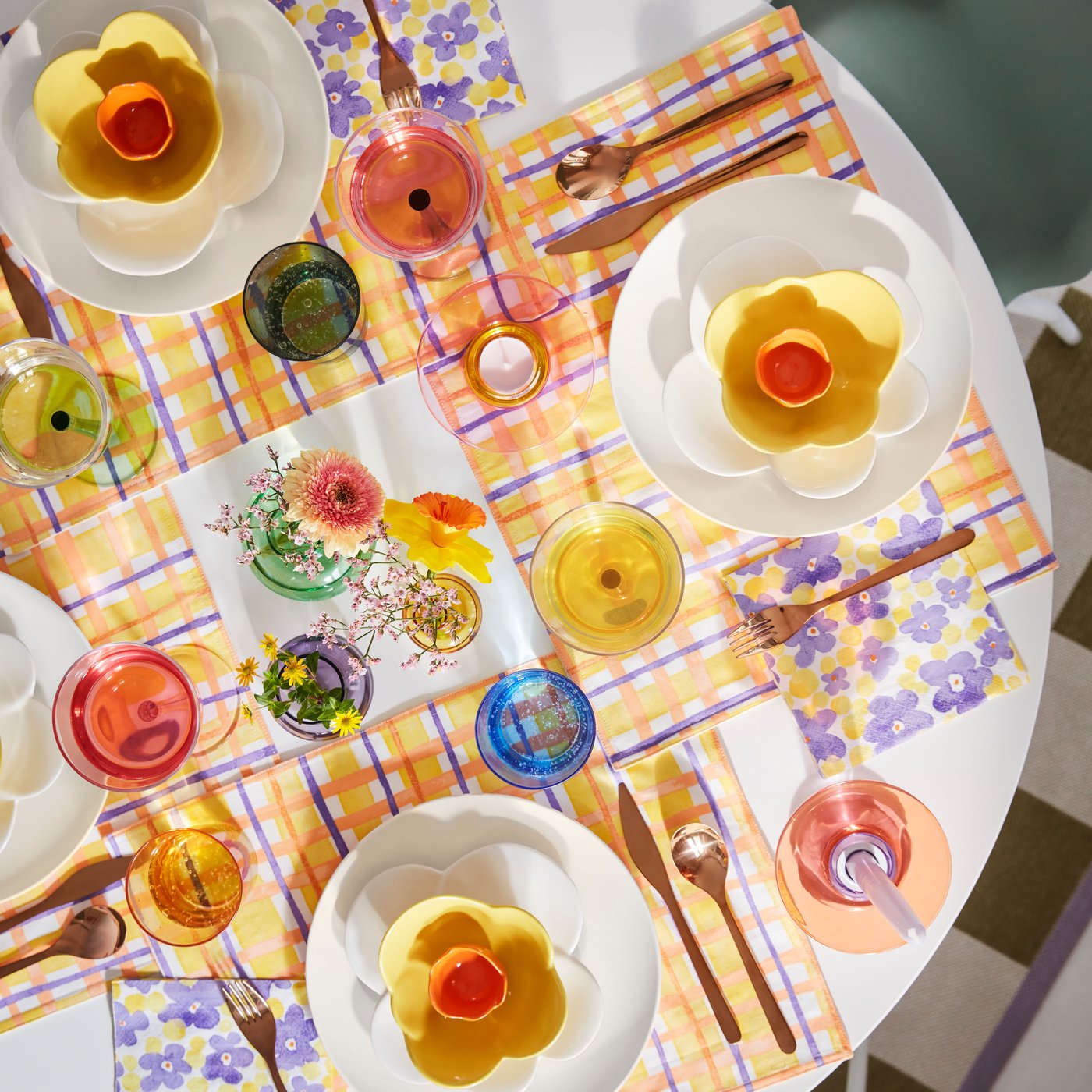 Colourful TJÄRLEK paper napkins and cute dinnerware in the shape of flowers and eggs on a table set for brunch