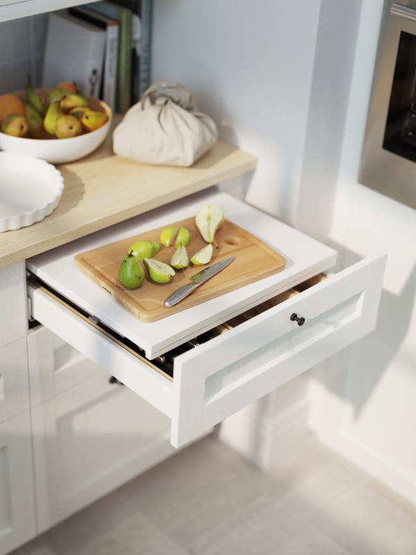 An UTRUSTA pull-out work surface inside a drawer in a kitchen
