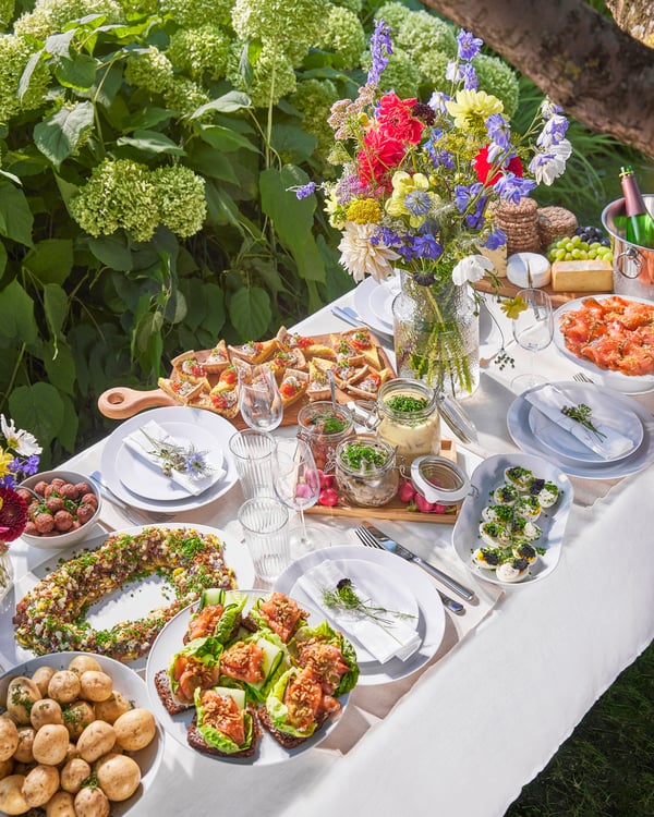 Bowls and plates in all kinds of colors containing typical Swedish snacks such as salmon, Swedish meatballs, and SILL SENAP pickled herring with mustard sauce.