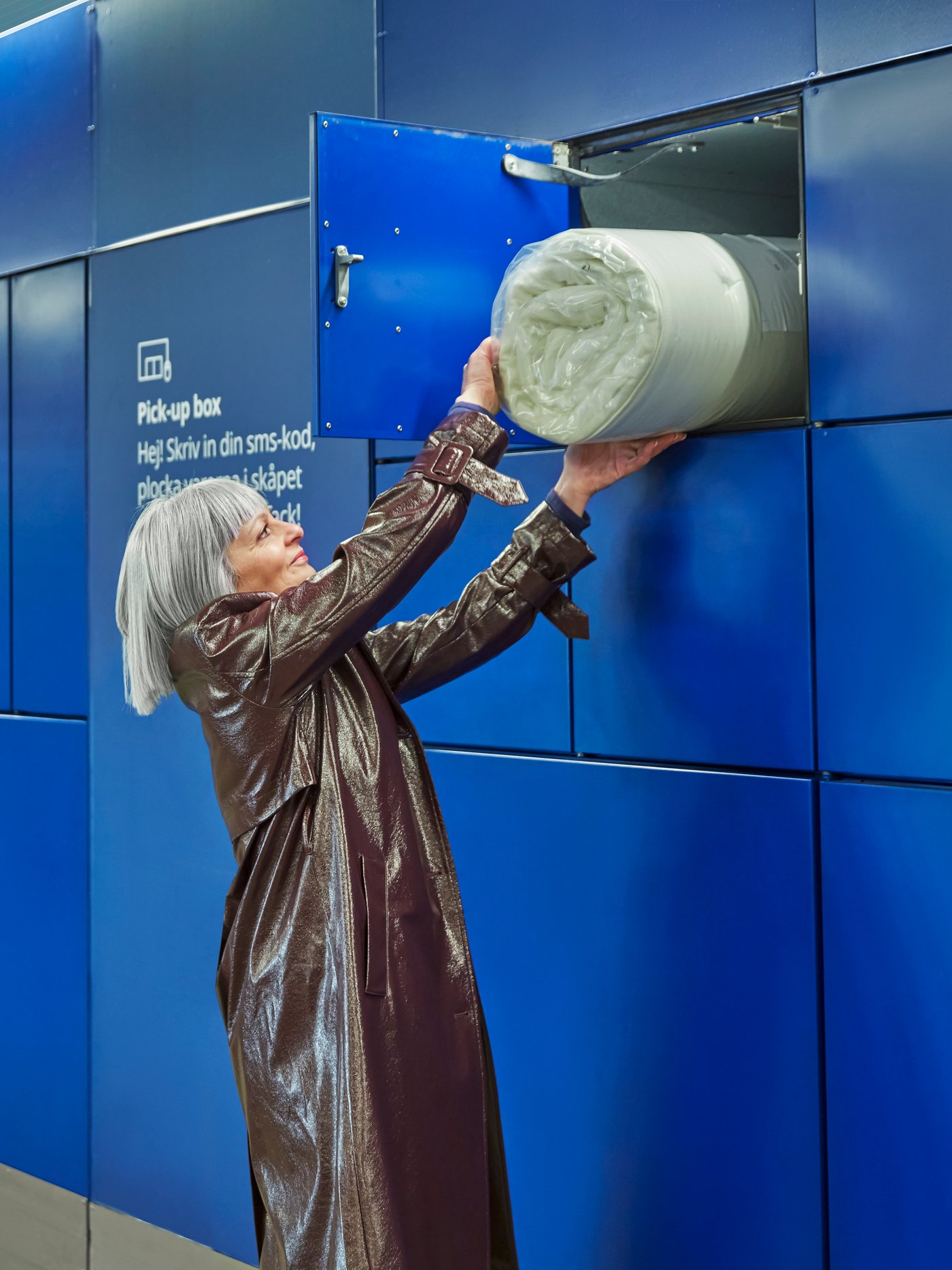 Eine Frau zieht eine IKEA Matratze aus einer Storebox.