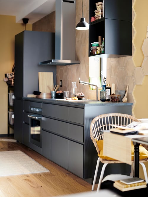 METOD Küche mit Unterschränken und einem Hochschrank für eine Kühl-/Gefrierkombination, einem ANRÄTTA Heißluftofen, einer MATÄLSKARE Dunstabzugshaube, einem NILSOVE Armlehnstuhl, IKEA 365+ Vorratsbehältern mit Deckeln und einer SKURUP Hängeleuchte.