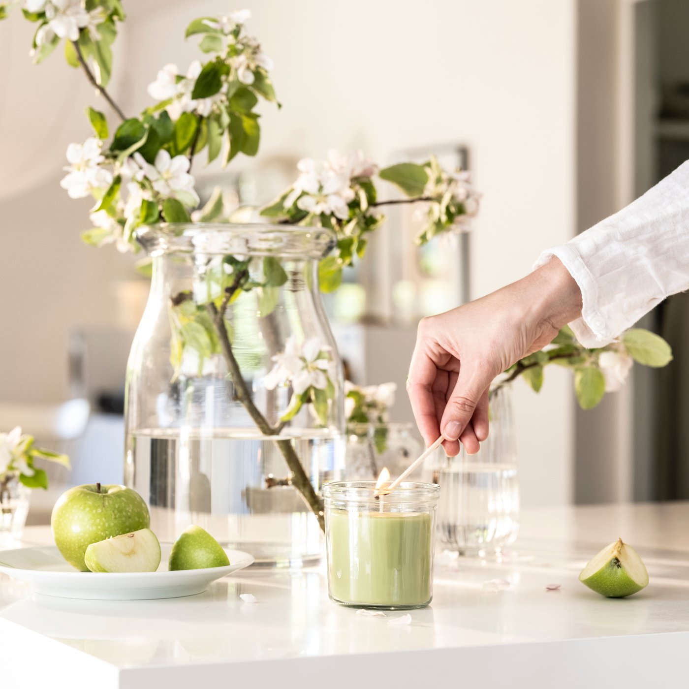 An Apple/light green LÖVSKOGSLUND scented candle in glass