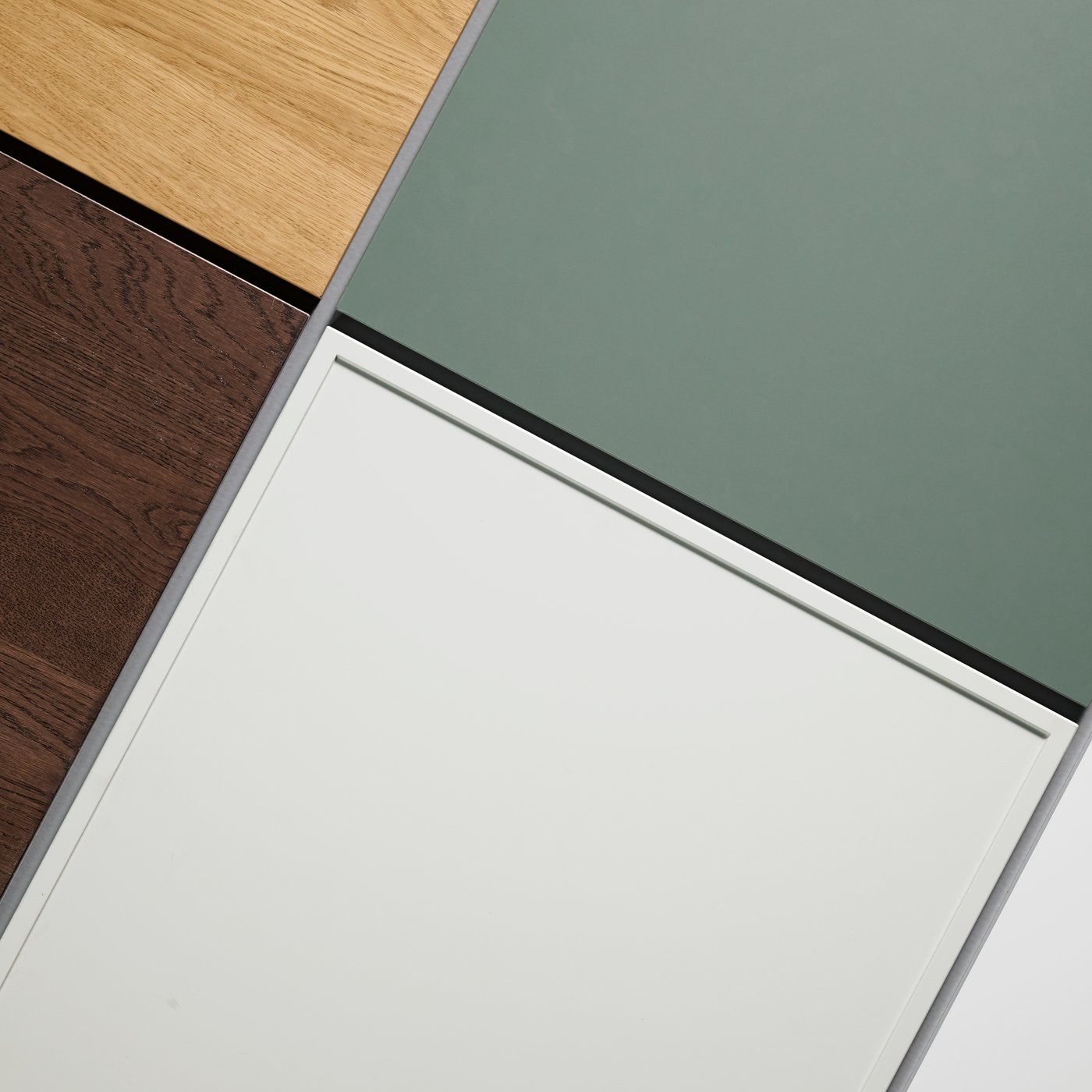 ASPUDDEN drawer front in light grey shown with a mix of other drawer fronts in green, oak effect, and dark wood.