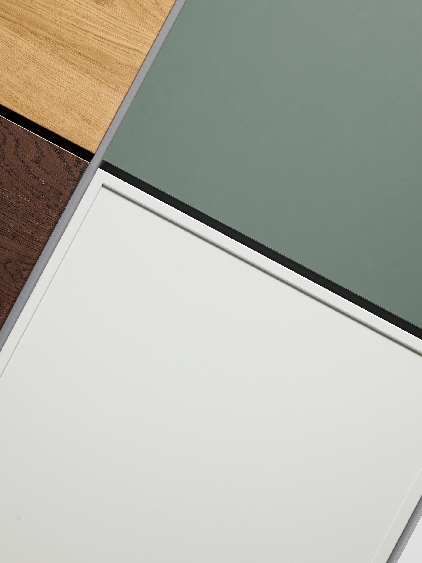 ASPUDDEN lådfront i ljusgrått visas med en blandning av andra lådfronter i grönt, ekeffekt och mörkt trä.