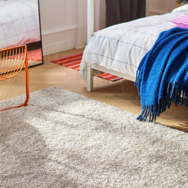An off-white ÄRENDE rug, high pile