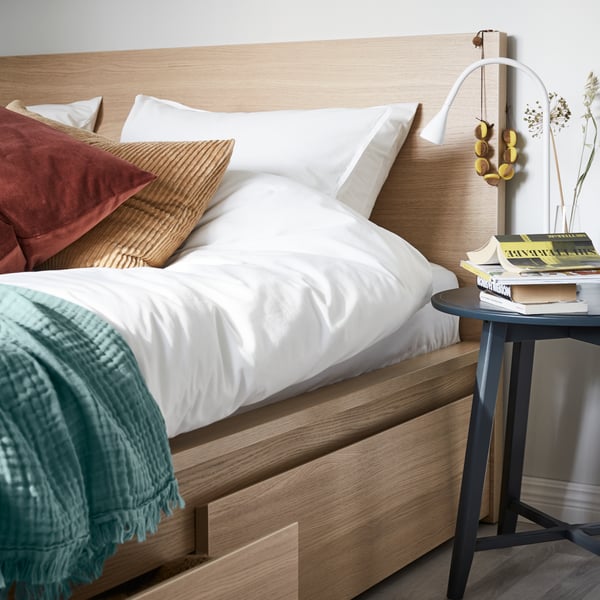 A dark beige ÅSVEIG cushion cover in the bedroom