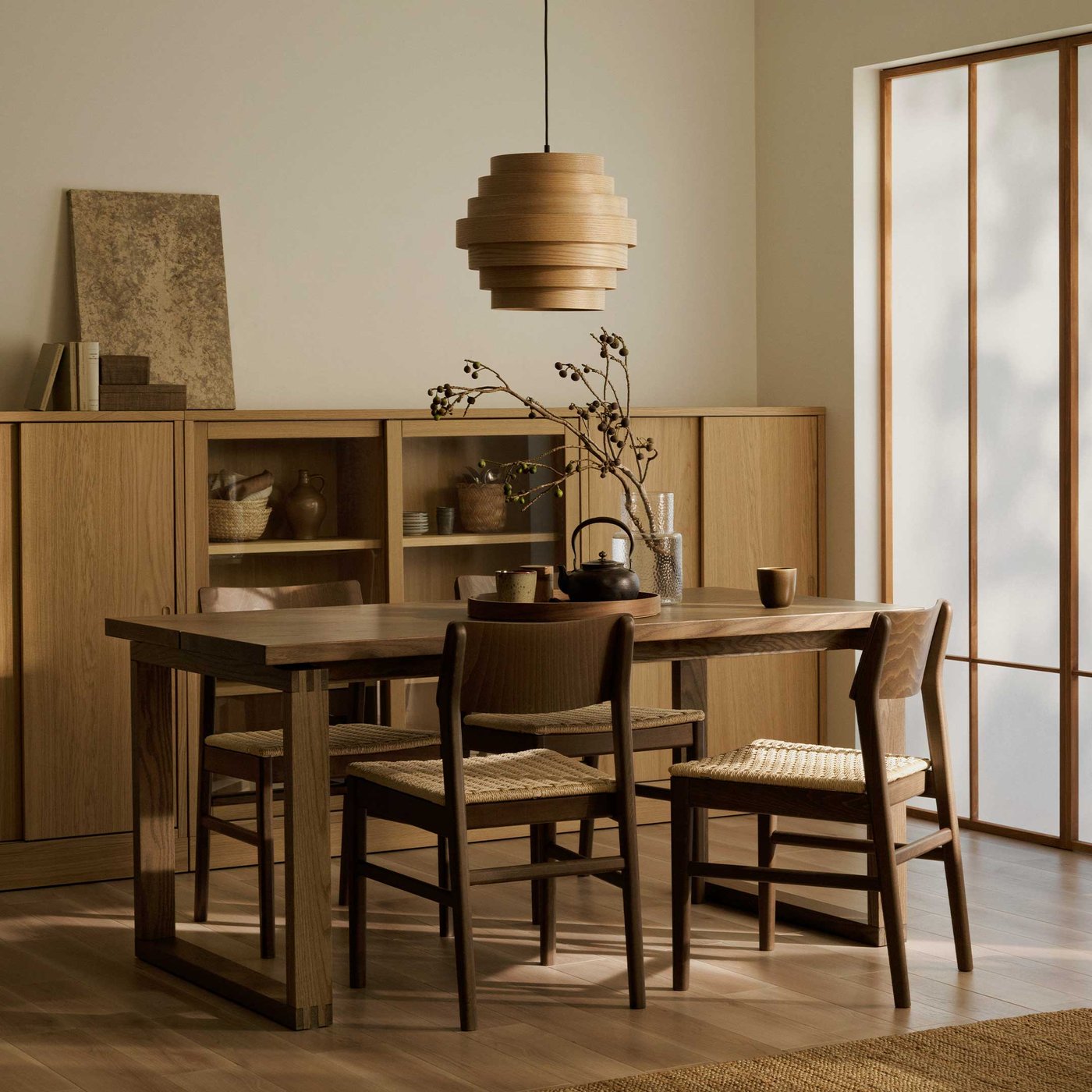 ウォールナットを基調とした家具と照明、障子風の採光が入り込むダイニングルーム。