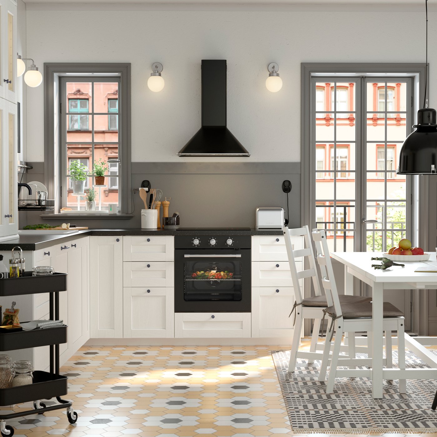 Cuisine de style traditionnel en noir et blanc avec table NORDVIKEN blanche entourée de trois chaises et d’un banc en pin.