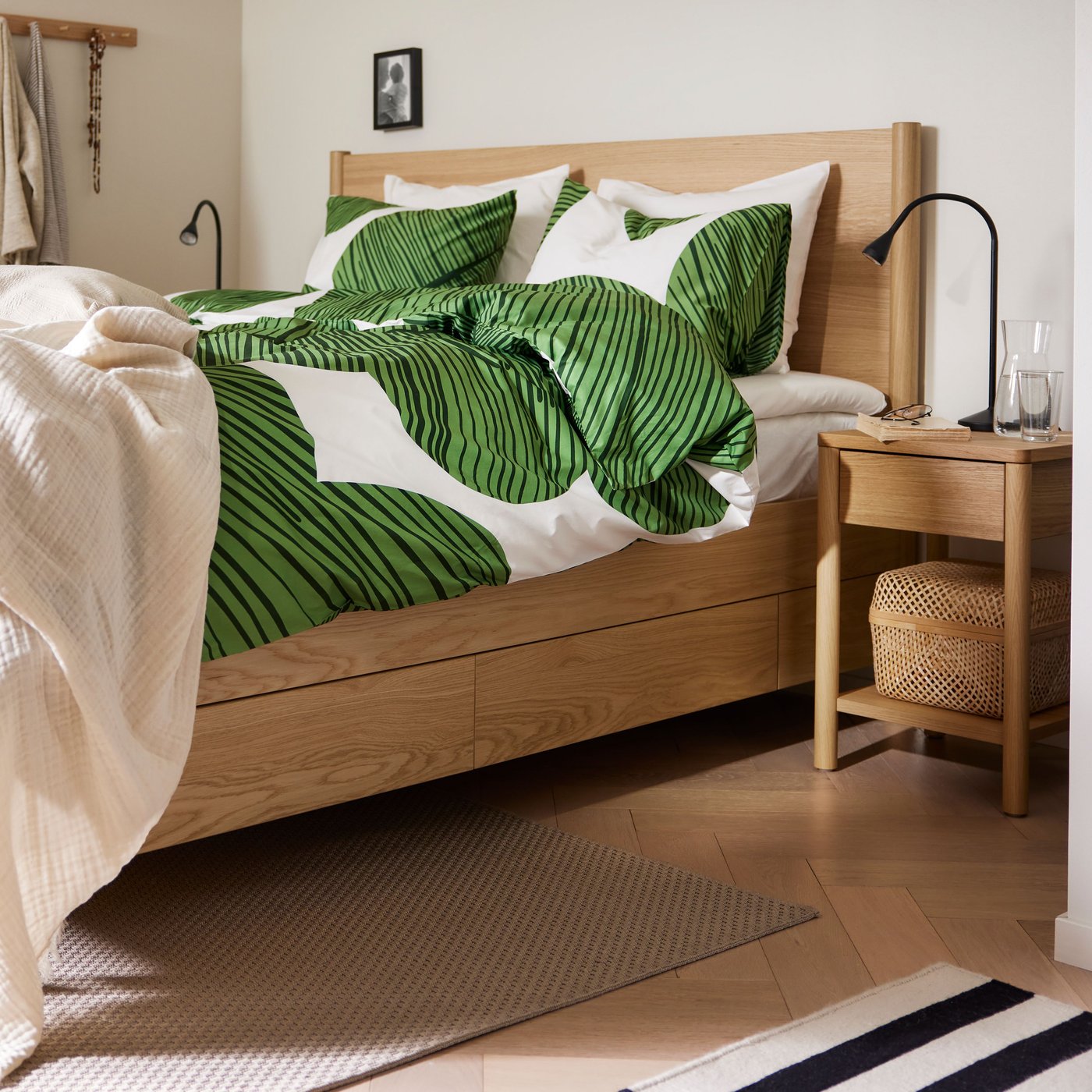 An oak veneer TONSTAD bed frame with storage