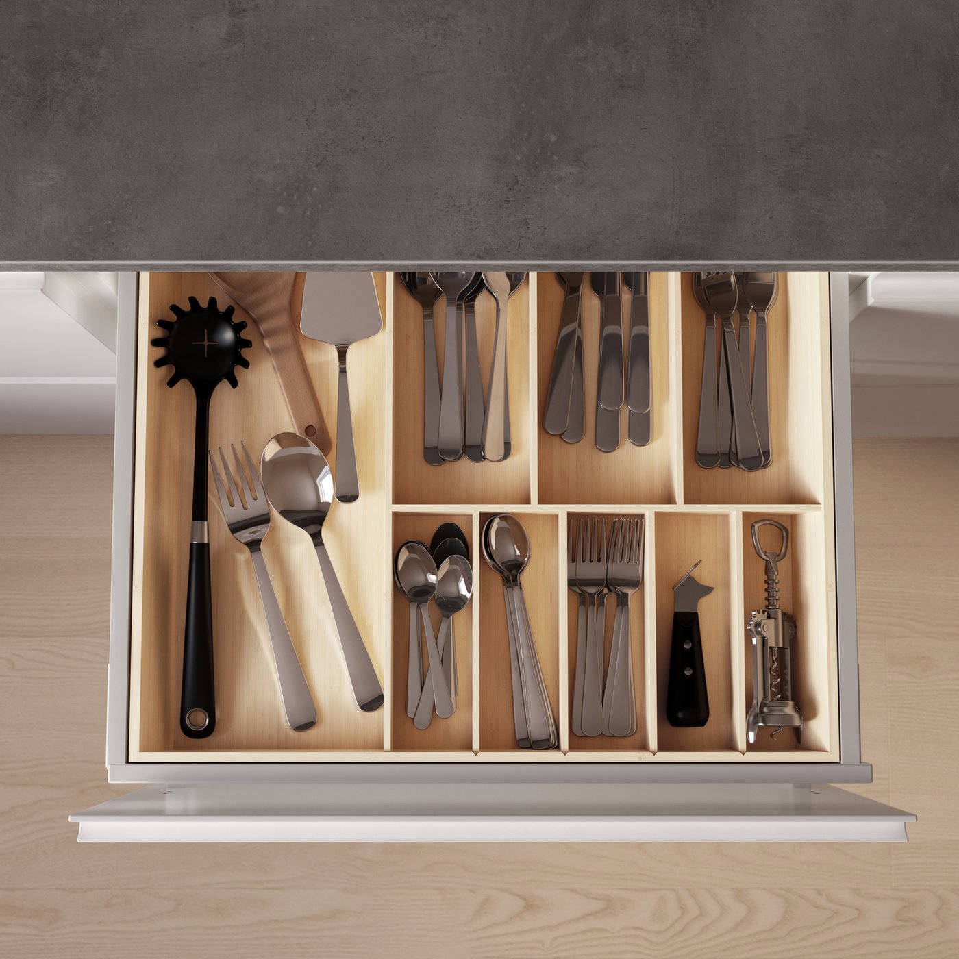 L'interno di un cassetto di una cucina con i divisori per organizzare le posate, visto dall'alto