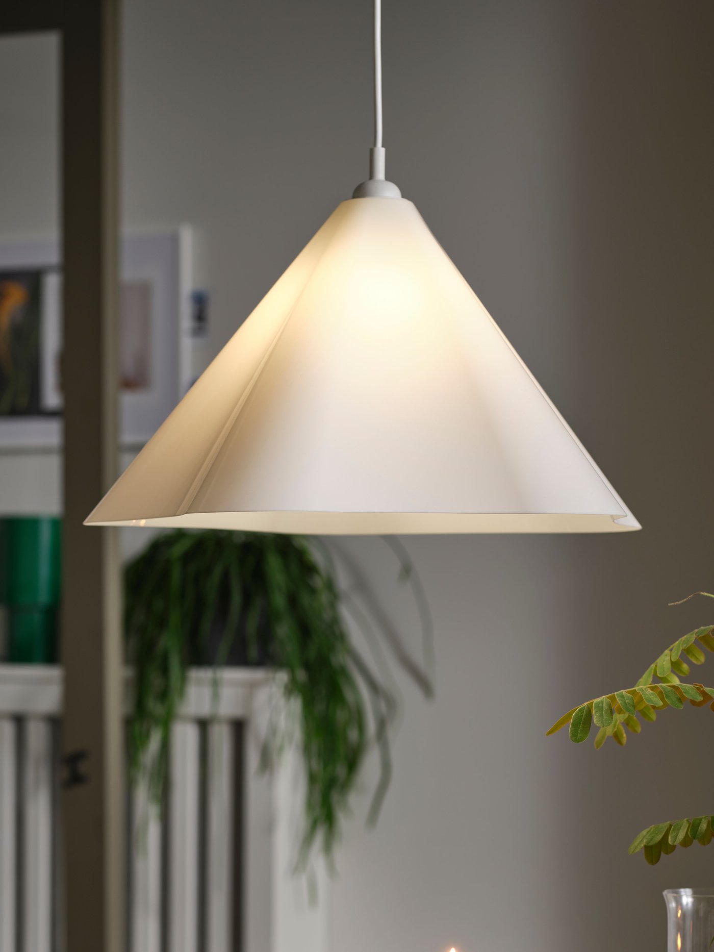 A white ZEBRASÄV plastic pendant lamp hangs above the dining table in the dining room.