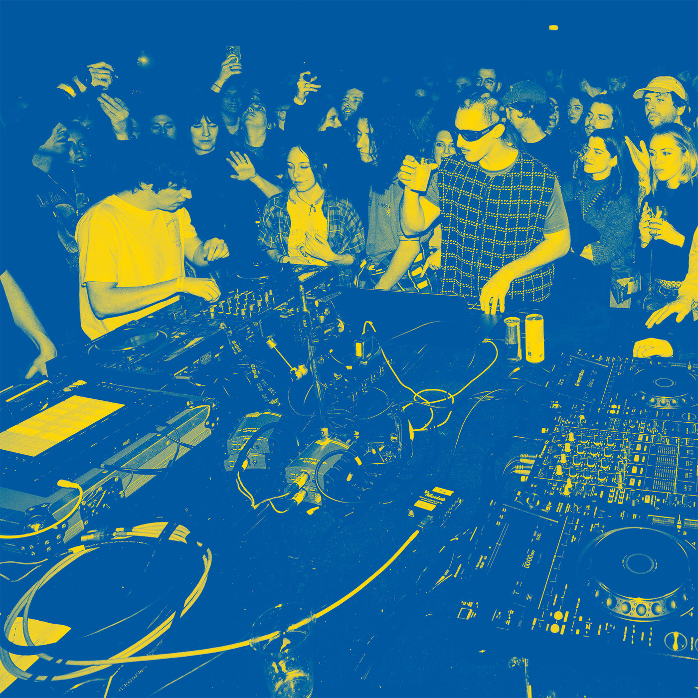 Vista sui DJ e sul loro setup mentre suonano su una pista da ballo affollata in un club.