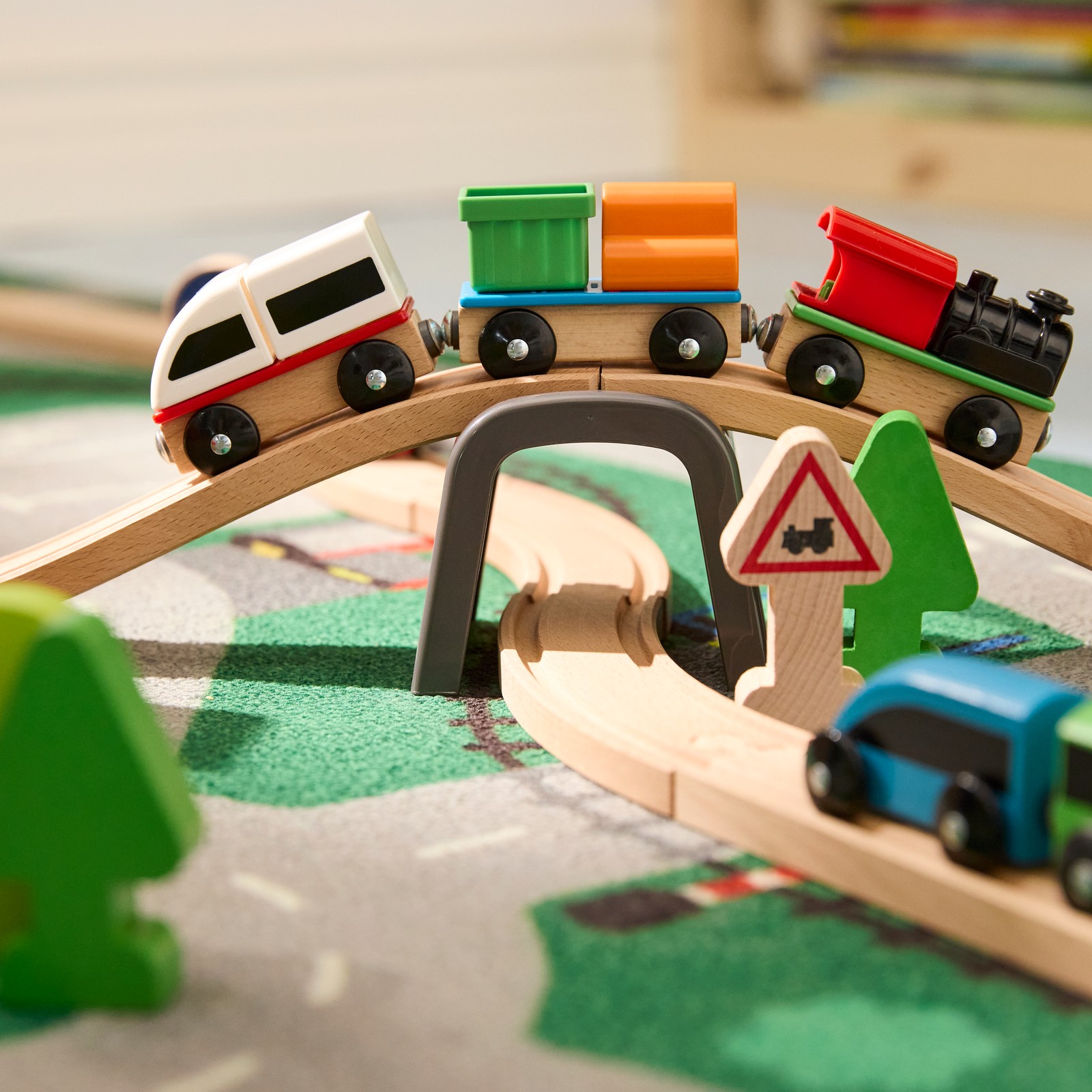 Krupni plan LILLABO železničkog mosta s jednim vozićem koji prolazi preko mosta i jednim na šinama ispod. Sve se nalazi na LILLABO tepihu.