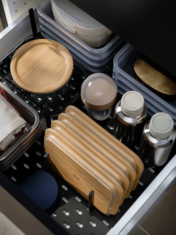 UPPDATERA pegboard drawers organiser storing bamboo lids, containers, and cloths, neatly arranged in a kitchen drawer.