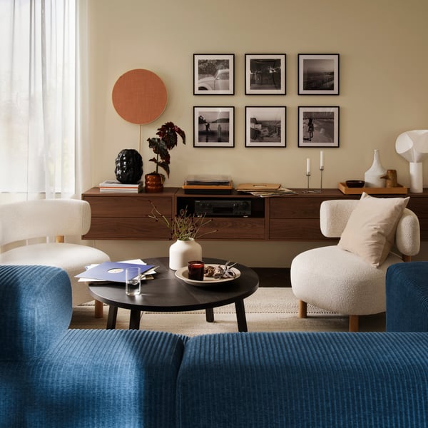 Beige BLODBJÖRK-maljakko olohuoneessa, jossa valkoiset STOCKHOLM-lepotuolit.